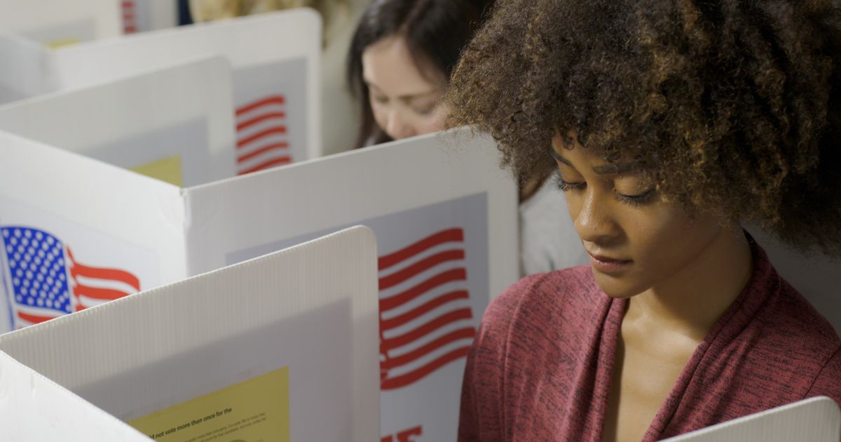 Two young women cast their vote at a polling station.