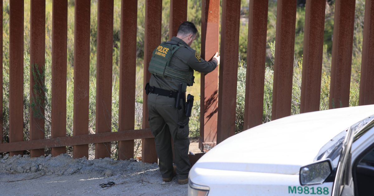 A US Border agent examines a vandalized section of the US-Mexico border fence near Campo, California, on April 4, 2024.