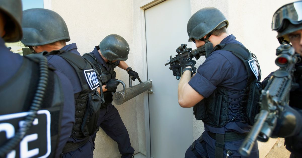 This Getty stock image depicts police breaking down a door.