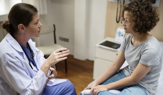 This image shows a doctor talking with her young female patient.