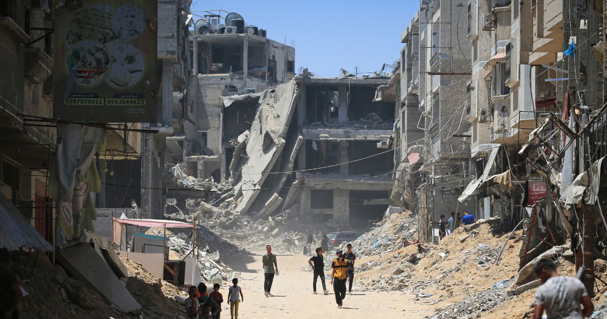 Palestinians walk past buildings destroyed in the Israeli bombardment of Khan Yunis in the southern Gaza Strip on Tuesday.