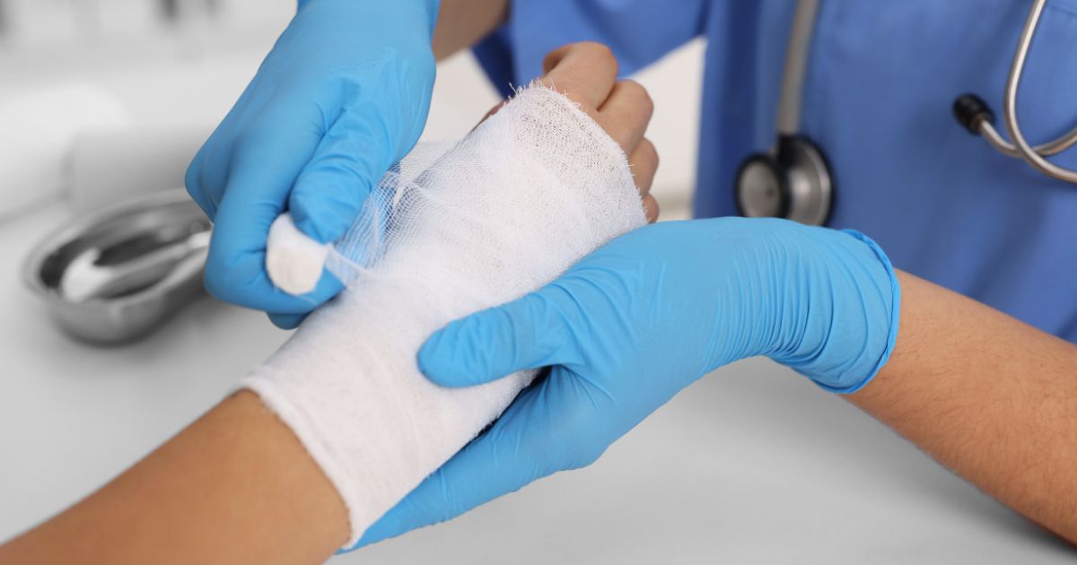 A stock photo shows a medical professional bandaging a patient's burned hand.