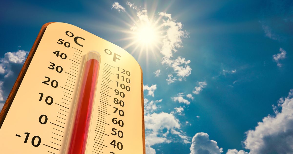 This stock image shows a thermometer with extreme summer temperatures under a bright sun.