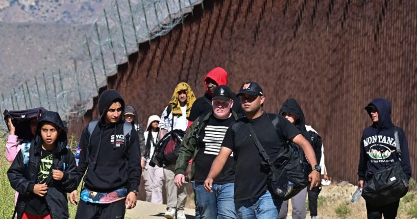 Illegal Immigrants walk on the U.S. side of the border wall in Jacumba Hot Springs, California, on June 5, 2024, after walking across from Mexico.