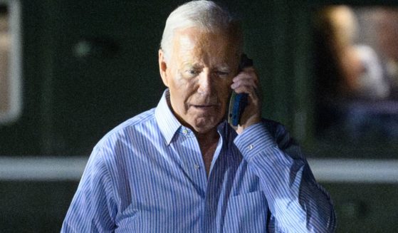 President Joe Biden speaks on the phone while walking from Marine One to board Air Force One before departing McGuire Air Force Base in New Jersey on Saturday.