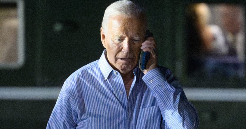 President Joe Biden speaks on the phone while walking from Marine One to board Air Force One before departing McGuire Air Force Base in New Jersey on Saturday.