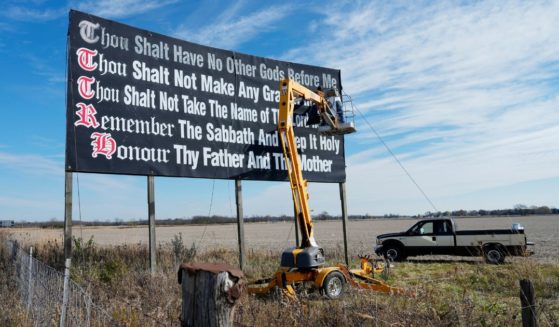 Workers repaint a Ten Commandments billboard off of Interstate 71near Chenoweth, Ohio, Tuesday, Nov. 7, 2023. Louisiana has become the first state to require that the Ten Commandments be displayed in every public school classroom under a bill signed into law Wednesday by Republican Gov. Jeff Landry.