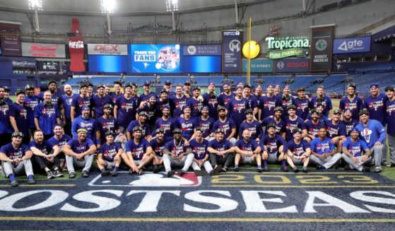 The Texas Rangers pose for a team photo after defeating the Tampa Bay Rays 7-1in Game Two of the Wild Card Series at Tropicana Field in St. Petersburg, Florida, on Oct. 4, 2023.