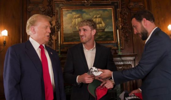 Before doing an interview on Logan Paul's, center, "Impaulsive" podcast, former President Donald Trump, left, gave Paul a gift.
