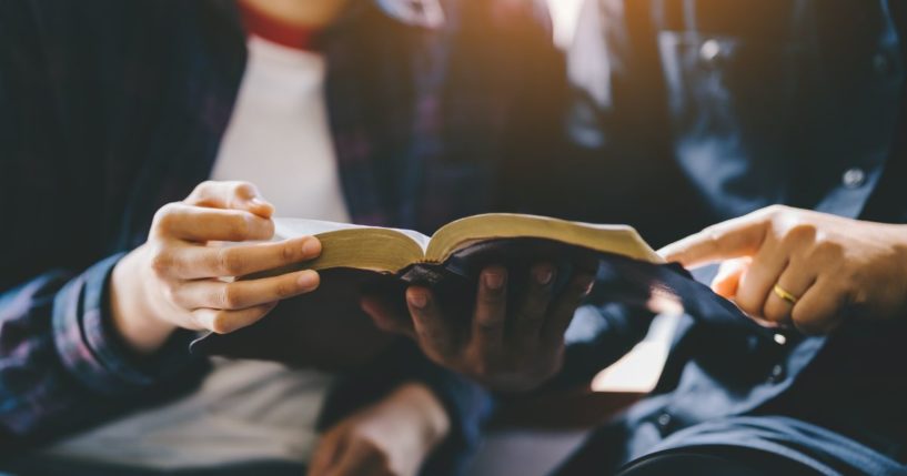 This image shows a young couple studying the Bible together.