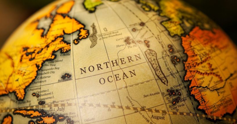 This image shows an up close view of a vintage world globe, focusing on the Northern Ocean and surrounding continents.