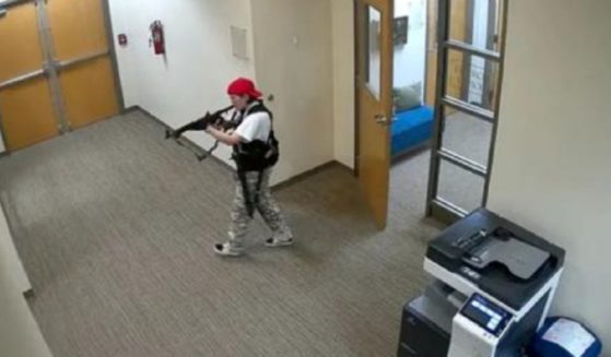 Audrey Hale, the killer at The Covenant School in Nasvhville in March 2023, stalks the school's halls with a rifle in a surveillance photo.