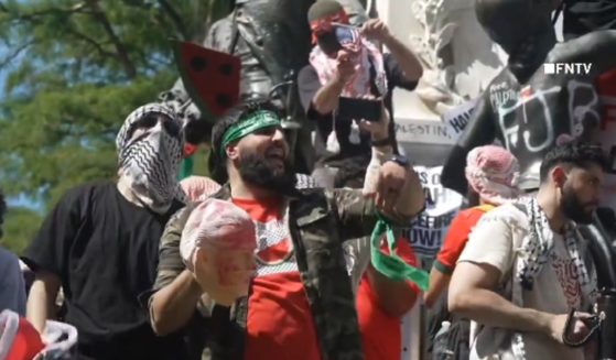 A pro-Palestinian protester holds a mask of Joe Biden that appears bloody during a demonstration Saturday in Washington, D.C.