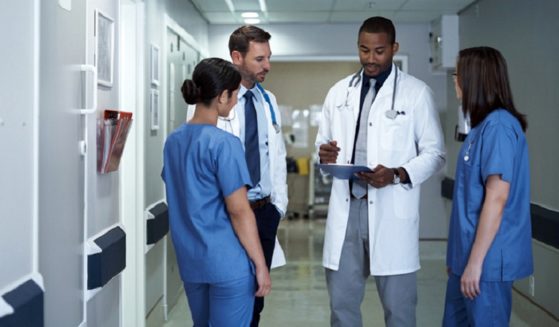A stock photo of doctors consulting in a hallway.