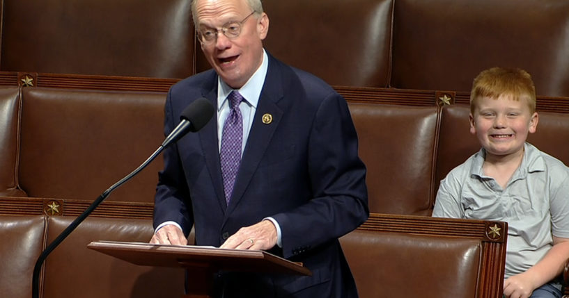 Rep. John Rose speaks on the floor of the House of Representatives in Washington, D.C., on Monday, as his son Guy smiles behind.