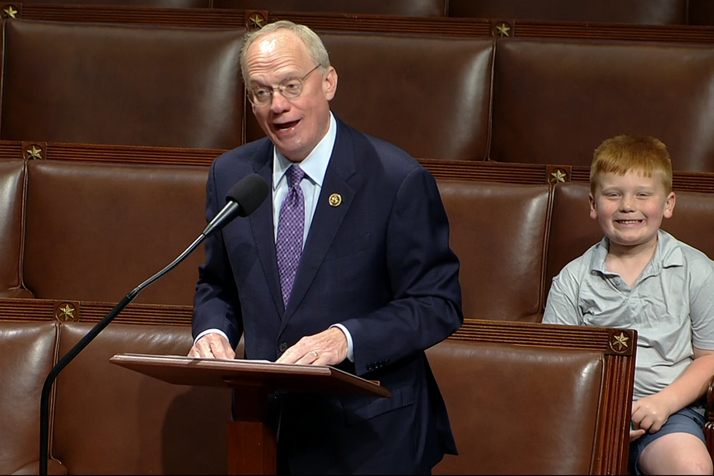 Rep. John Rose speaks on the floor of the House of Representatives in Washington, D.C., on Monday, as his son Guy smiles behind.