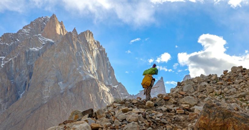 This picture taken on July 12, 2023, shows a Pakistani porter hiking on the trail between Askole and K2, world's second tallest mountain in the Karakoram range of GilgitBaltistan, Pakistan.