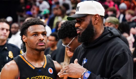 NBA star LeBron James right, talks with his son, Bronny James, in a March 2023 file photo from the McDonald's High School Boys All-American Game in Houston.