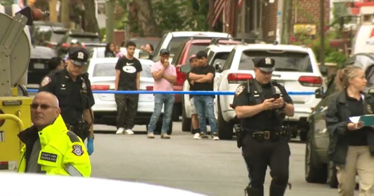 Police and onlookers are at the scene where a man was killed while crossing the street in Brooklyn, New York.