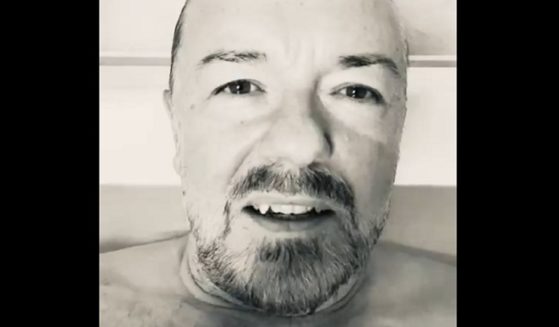 Comedian Ricky Gervais is pictured with his head and neck above the waterline in a bathtub.