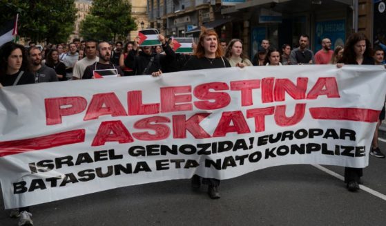 Pro-Palestinian youth wearing a banner reading 'Free Palestine, Genocidal Israel, European Union and NATO complicit' shout slogans at a demonstration in support of the Palestinians and the Gaza strip on June 6, 2024 in San Sebastian, Spain.