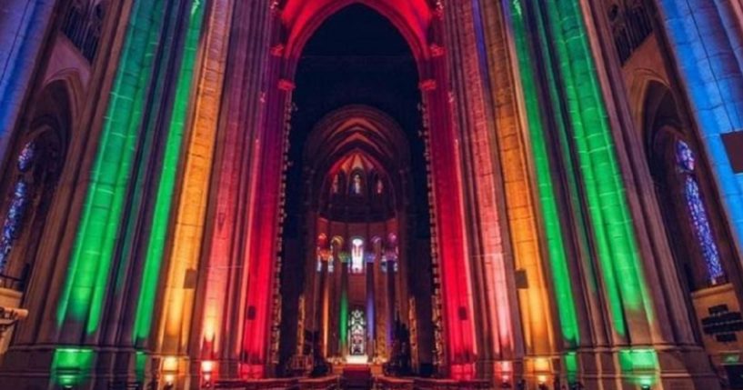 The interior of New York City's St. John the Divine Cathedral lit up with rainbow colors.