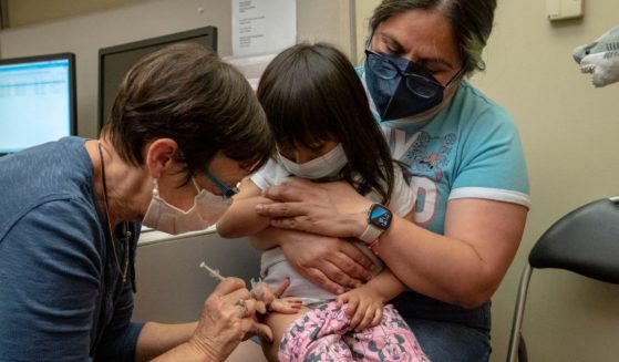 Deni Valenzuela, 2, receives her first dose of the Pfizer COVID-19 vaccination from nurse Deborah Sampson while being held by her mother, Xihuitl Mendoza, at UW Medical Center - Roosevelt in Seattle on June 21, 2022.