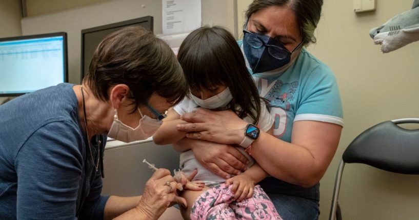 Deni Valenzuela, 2, receives her first dose of the Pfizer COVID-19 vaccination from nurse Deborah Sampson while being held by her mother, Xihuitl Mendoza, at UW Medical Center - Roosevelt in Seattle on June 21, 2022.