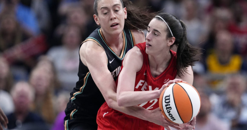 Indiana Fever's Caitlin Clark, right, makes a pass as New York Liberty's Breanna Stewart, left, defends during the first half of a WNBA basketball game in Indianapolis on Saturday.