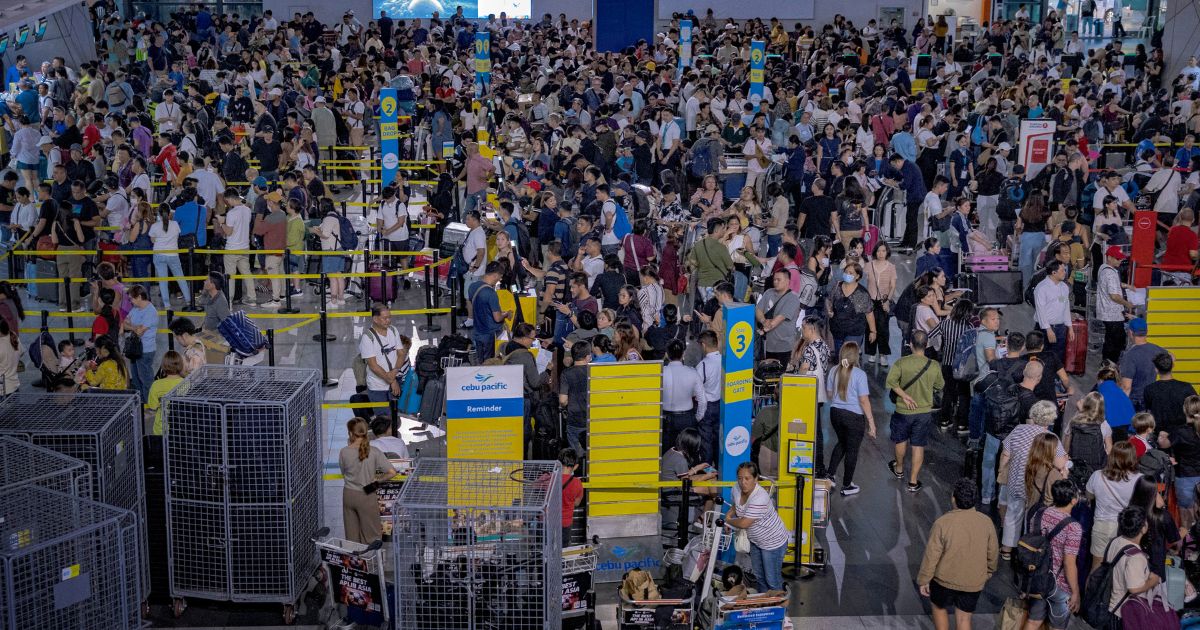 Long lines of passengers form at the check-in counters at Ninoy Aquino International Airport in Manila amid a global IT disruption on Friday.