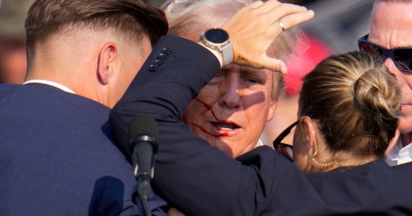 Former President Donald Trump is helped off the stage by U.S. Secret Service agents after an assassination attempt at a campaign event in Butler, Pennsylvania, on Saturday.