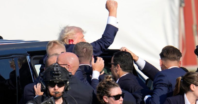 Former President Donald Trump is helped into a vehicle by Secret Service agents after an assassination attempt at a rally in Butler, Pennsylvania, on Saturday.