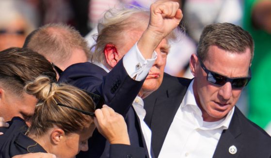 Former President Donald Trump is helped off the stage by U.S. Secret Service agents after an assassination attempt at a campaign event in Butler, Pennsylvania, on Saturday.