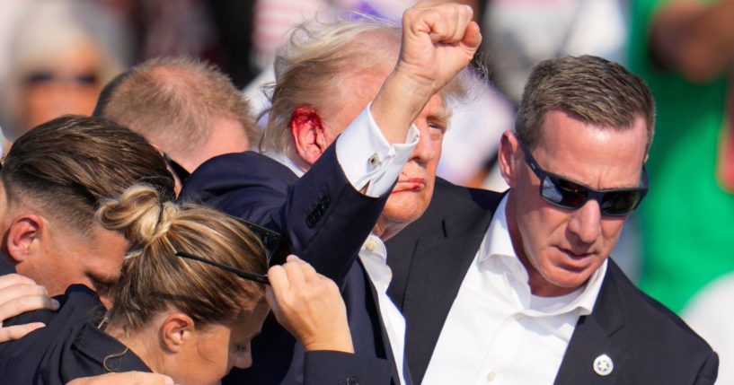 Former President Donald Trump is helped off the stage by U.S. Secret Service agents after an assassination attempt at a campaign event in Butler, Pennsylvania, on Saturday.