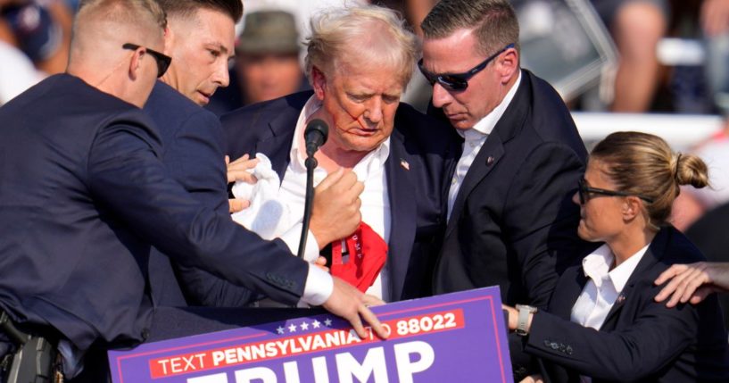 Former President Donald Trump is helped to his feet and escorted off stage after an assassination attempt at a campaign rallying Butler, Pennsylvania, on Saturday.