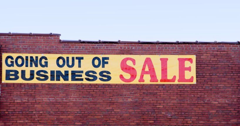 A stock photo shows a sign on the side of a brick building advertising a "Going out of business sale."