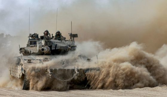 Israeli soldiers sit in the turret of a moving main battle tank at a position along the border with the Gaza Strip and southern Israel on Sunday.