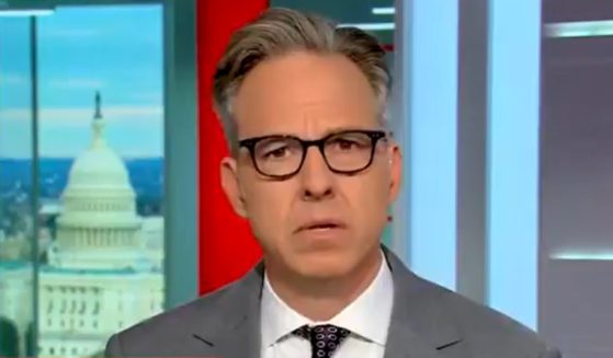 Jake Tapper reacts after reading a quote from President Joe Biden.