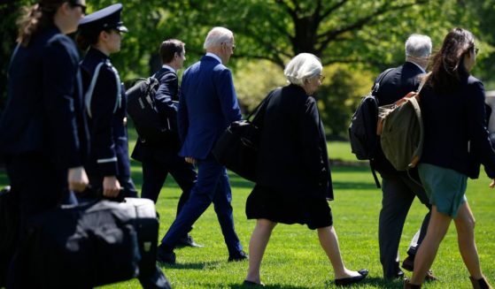 President Joe Biden, fourth from left, is accompanied by staff, including Deputy Chief of Staff Bruce Reed and senior advisers Anita Dunn and Mike Donilon, as they depart the White House in Washington on April 23.