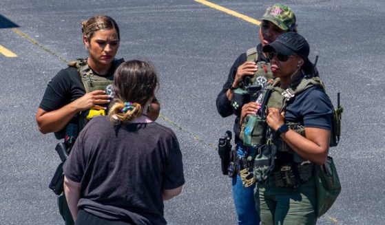 Officers talk to a girl in a parking lot on May 22. The U.S. Marshals Service, along with federal, state and local partner agencies, led Operation We Will Find You 2, a six-week national operation from May 20 to June 24.