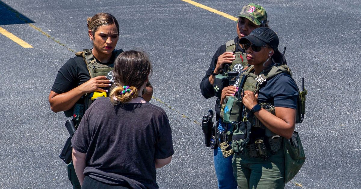 Officers talk to a girl in a parking lot on May 22. The U.S. Marshals Service, along with federal, state and local partner agencies, led Operation We Will Find You 2, a six-week national operation from May 20 to June 24.
