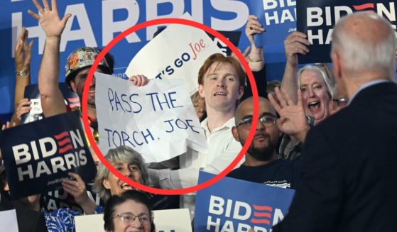 A supporter of President Joe Biden holds a sign that reads, "Pass the torch, Joe" Friday during a campaign event in Madison, Wisconsin.