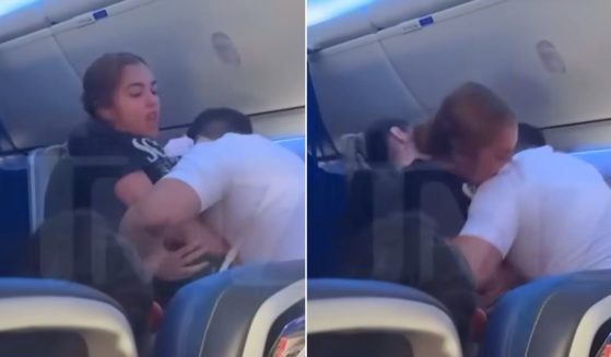 A passenger bites a flight attendant who is restraining her.