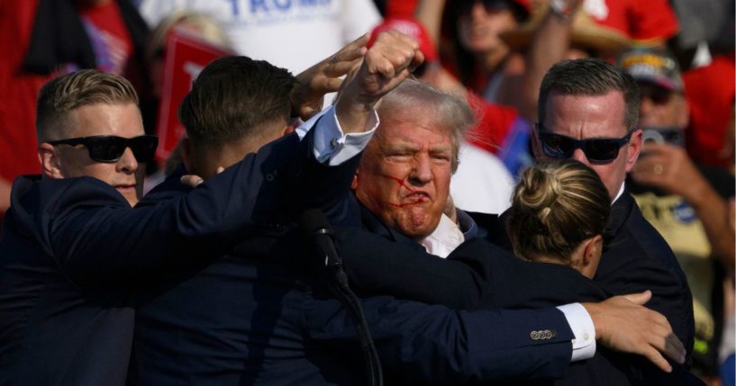 Secret Service agents surround Republican presidential candidate former President Donald Trump onstage after he was injured at a rally.