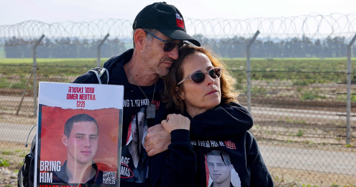 Relatives of Israeli hostages held by the Palestinian Hamas movement carry a picture of Omer Neutra, 22, in Kibbutz Nirim along the fence on the Gaza border.