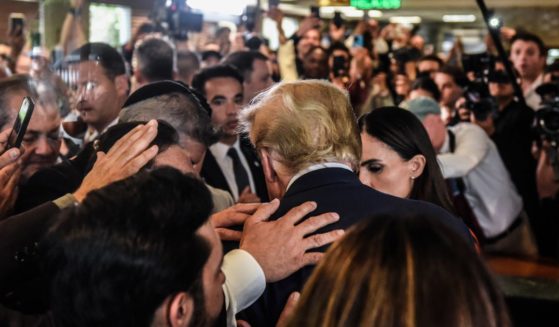 Former U.S. President Donald Trump prays with supporters as he visits the Versailles restaurant in the Little Havana neighborhood after being arraigned at the Wilkie D. Ferguson Jr. United States Federal Courthouse on June 13, 2023 in Miami, Florida.