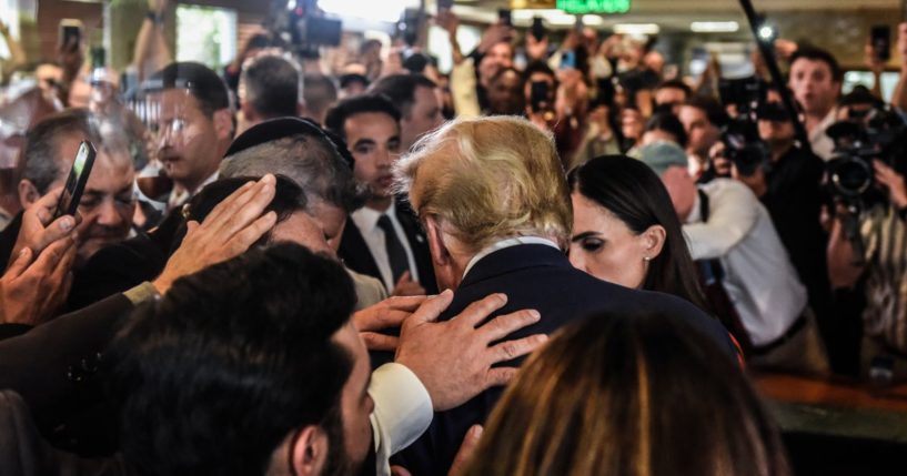 Former U.S. President Donald Trump prays with supporters as he visits the Versailles restaurant in the Little Havana neighborhood after being arraigned at the Wilkie D. Ferguson Jr. United States Federal Courthouse on June 13, 2023 in Miami, Florida.