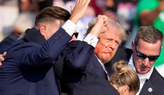 Former President Donald Trump is helped off the stage by U.S. Secret Service agents at a campaign event in Butler, Pennsylvania, after being shot.