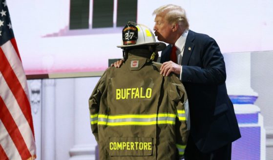 Republican presidential nominee and former President Donald Trump embraces the firefighter uniform of Corey Comperatore as he speaks on stage on the fourth day of the Republican National Convention at the Fiserv Forum in Milwaukee on Thursday.