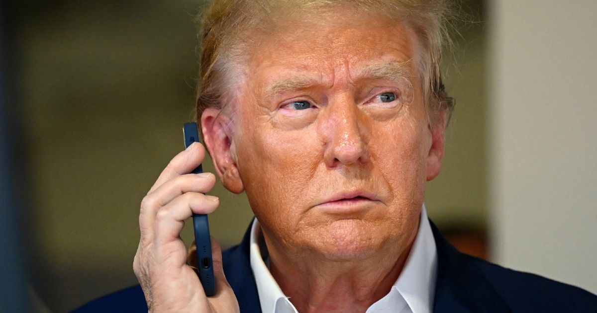 Former President Donald Trump talks on the phone in the McLaren garage prior to the F1 Grand Prix of Miami at Miami International Autodrome on May 5.